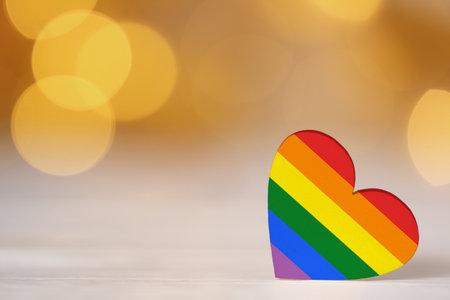 Heart in LGBT colors on table against blurred lights, space for text.の写真素材