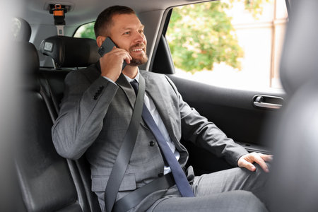 Happy man talking on phone in modern carの写真素材