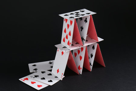 House of playing cards on black background