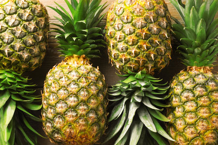 Fresh ripe pineapples on wooden table, above viewの写真素材
