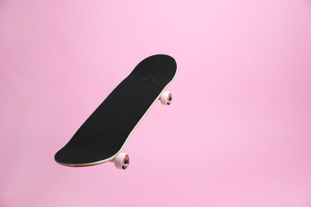 One skateboard on pink background, space for text. Sports equipmentの写真素材