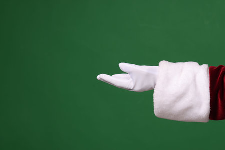 Santa Claus holding something on green background, closeup. Space for textの写真素材