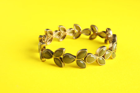 Beautiful bijouterie. Stylish bracelet on yellow background, closeupの写真素材