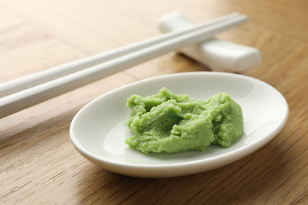 Hot wasabi paste and chopsticks on wooden table, closeupの写真素材