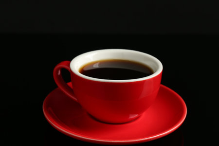 Red cup with coffee on black background, closeupの写真素材