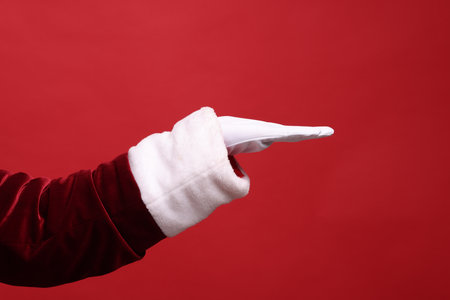 Santa Claus holding something on red background, closeupの写真素材