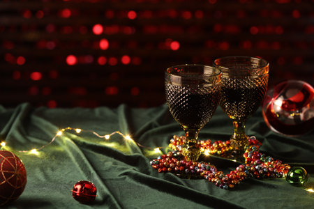 Glasses with red wine and beautiful Christmas decor on table. Space for textの写真素材