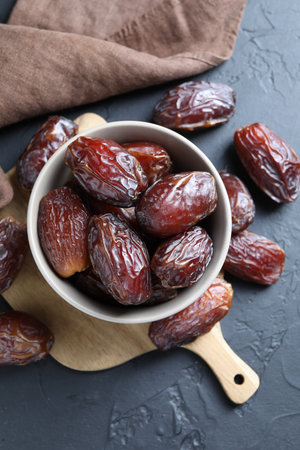 Tasty dried dates on gray table, top view