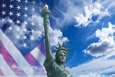 Statue of Liberty against American flag and sky