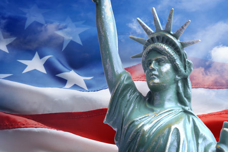 Statue of Liberty against American flag and sky