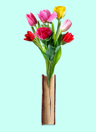 Closed book with beautiful flowers between pages on light blue backgroundの写真素材