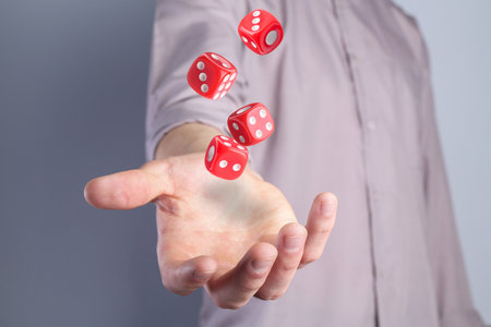 Man throwing red dice on gray background, closeupの写真素材