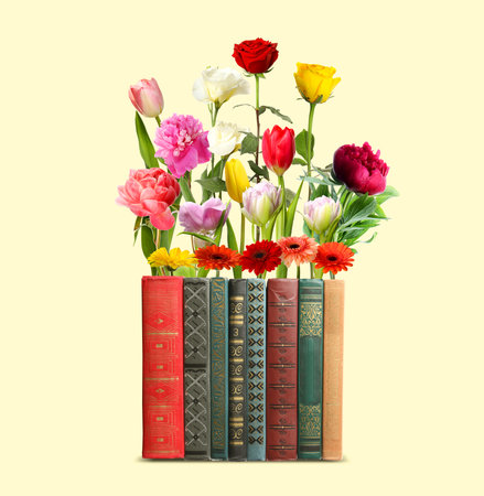 Closed books with beautiful flowers between pages on beige backgroundの写真素材