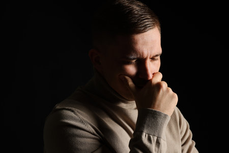 Distressed young man on black background