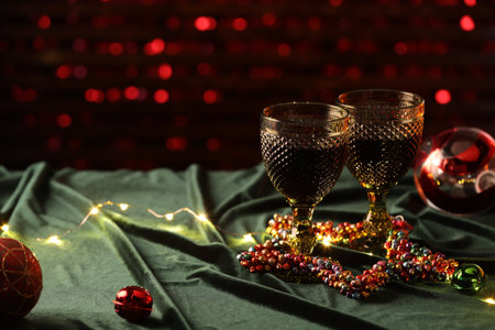 Glasses with red wine and beautiful Christmas decor on table. Space for textの写真素材