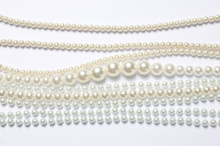 Beautiful pearl necklaces on white background, flat layの写真素材
