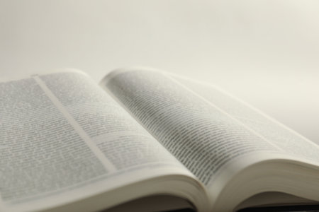 Open book in English language on white background, closeup
