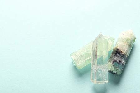 Beautiful natural gemstones on light blue background, top view. Space for textの写真素材