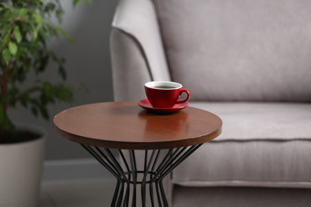 Cup of drink on wooden coffee table indoorsの写真素材