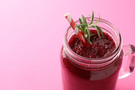 Fresh beetroot smoothie with rosemary in mason jar on pink background, closeup. Space for textの写真素材
