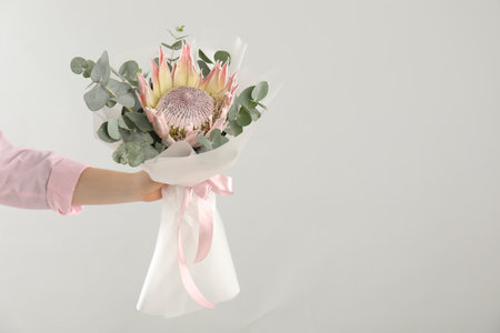 Woman with beautiful bouquet on light background, closeup. Space for textの写真素材
