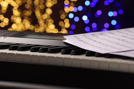 Sheets with notes on piano against blurred lights, closeup. Bokeh effectの写真素材
