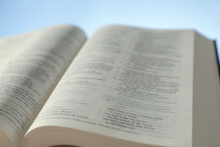 Open Holy Bible in English language on light blue background, closeupの写真素材