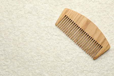 One wooden hair comb on beige background, top view. Space for textの写真素材