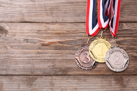 Golden, silver and bronze medals on wooden background, top view. Space for textの写真素材