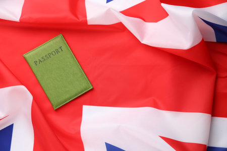 Passport in green cover on flag of United Kingdom, top view. Space for textの写真素材