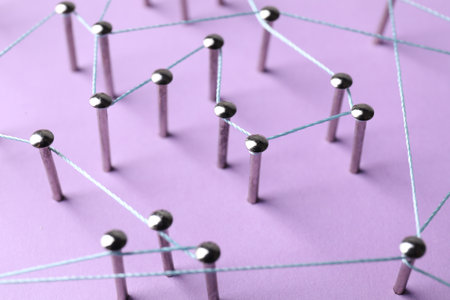 Network connection. Nails linked together by thread on violet background, closeupの写真素材