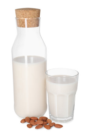 Glass and bottle of almond milk and nuts isolated on whiteの写真素材