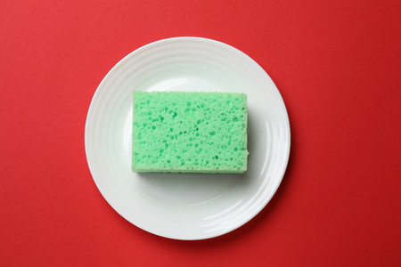 Plate with sponge on red background, top viewの写真素材