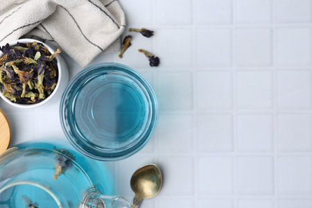 Delicious butterfly pea flower tea on white tiled table, flat lay. Space for textの写真素材