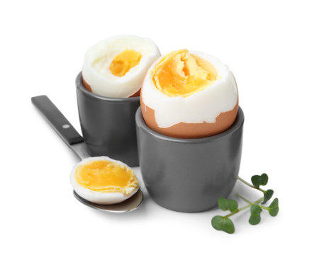 Soft boiled eggs and spoon isolated on whiteの写真素材