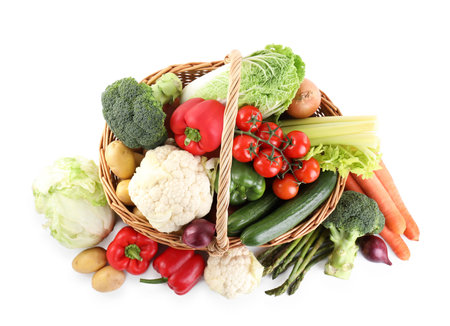 Different ripe vegetables in basket isolated on white, top viewの写真素材