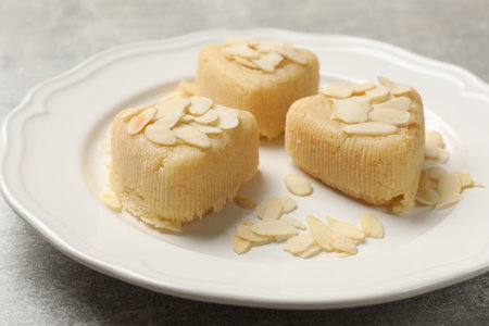 Pieces of delicious sweet semolina halva with almond flakes on light gray table, closeupの写真素材