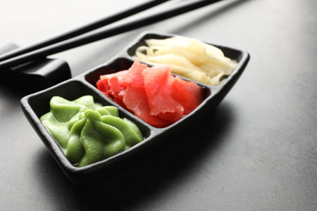 Hot wasabi paste, ginger and chopsticks on grey table, closeupの写真素材