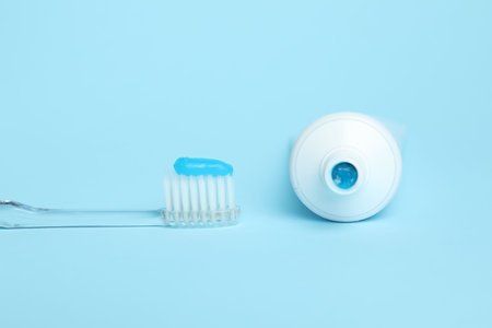 Toothbrush with toothpaste and tube on light blue backgroundの写真素材