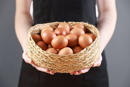 Basket of fresh brown eggs on grey background, closeupの写真素材