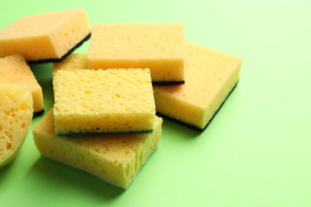 Pile of sponges on green background, closeupの写真素材
