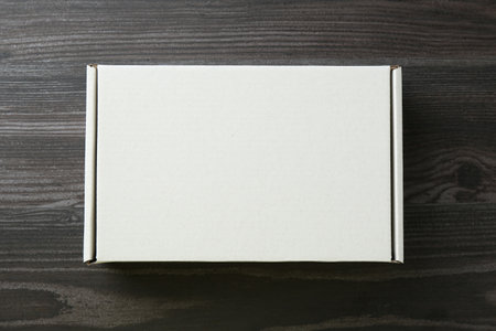 One blank cardboard box on wooden background, top view. Mockup for design