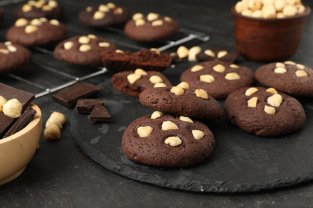 Tasty chocolate cookies with hazelnuts on black table, closeupの写真素材