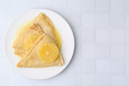 Delicious Crepes Suzette on white tiled table, top viewの写真素材