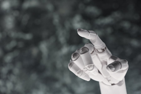 Artificial intelligence. Robot hand pointing at something on gray blurred background, space for textの写真素材