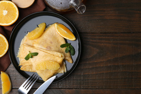 Delicious crepes served on wooden table, flat lay. Space for textの写真素材