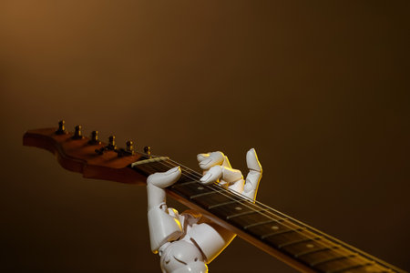 Artificial intelligence. Robot hand playing guitar on brown background, closeupの写真素材