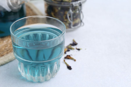 Delicious butterfly pea flower tea on light table, closeup. Space for textの写真素材