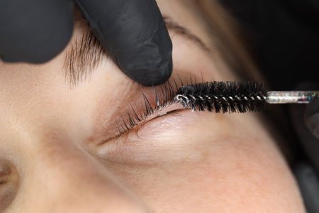 Esthetician brushing woman's lashes after lamination procedure, closeupの写真素材