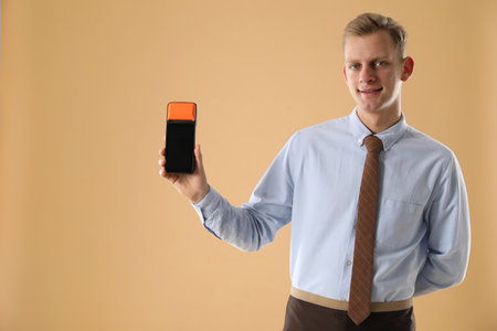 Person holding payment terminal on beige background, space for textの写真素材